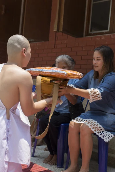 Man receive monk robe from their parent in buddhist monk ordinat