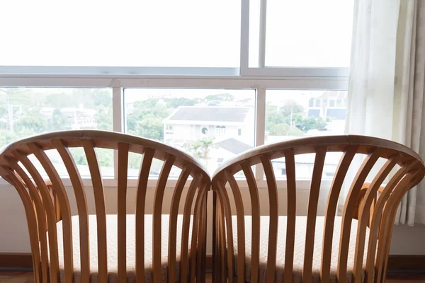 Wooden chair beside window