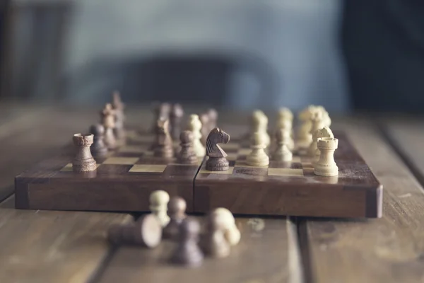 Pawn and chessboard game on wooden table, vintage tone and selec