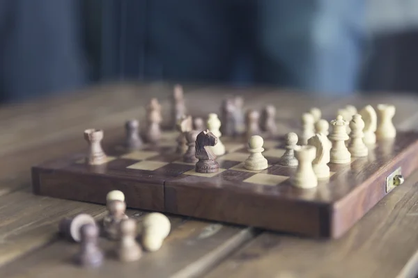 Pawn and chessboard game on wooden table, vintage tone and selec