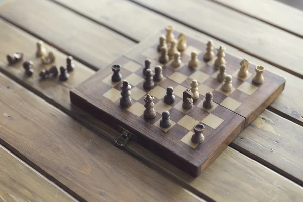 Pawn and chessboard game on wooden table, vintage tone and selec