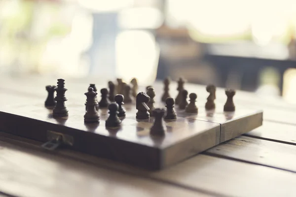 Pawn and chessboard game on wooden table, vintage tone and selec