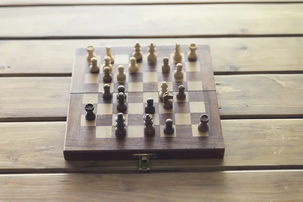Pawn and chessboard game on wooden table, vintage tone and selec