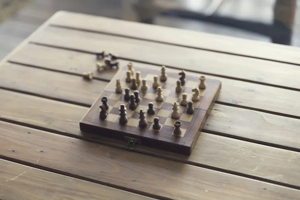 Pawn and chessboard game on wooden table, vintage tone and selec