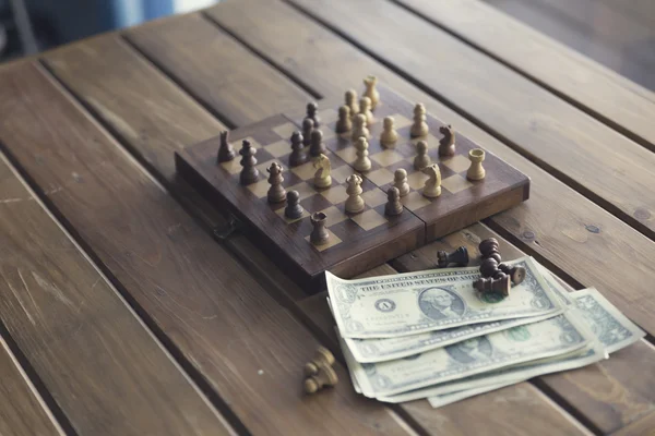 Pawn, chessboard game and banknote on wooden table, vintage tone