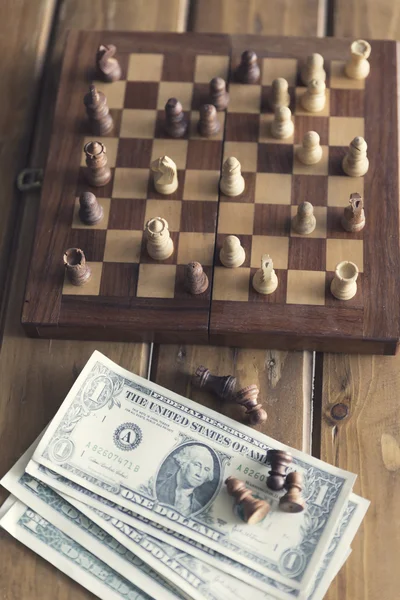 Pawn, chessboard game and banknote on wooden table, vintage tone