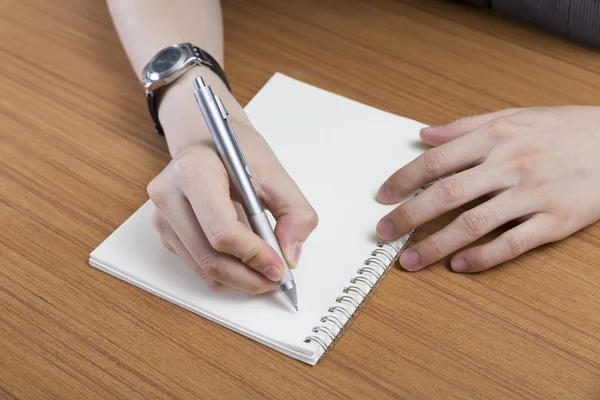 Businessman writing note on notepad