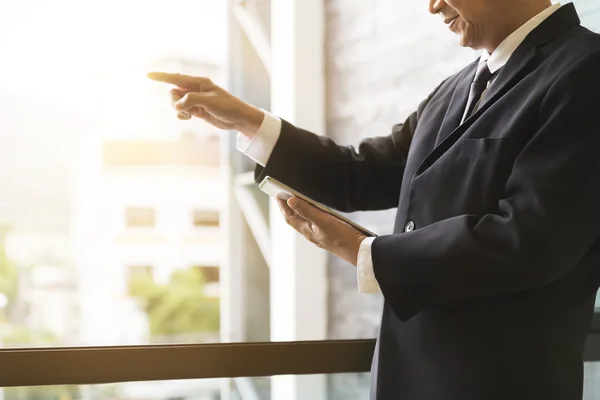 Businessman holding tablet and pointing his finger