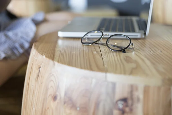 Eyeglasses with laptop computer notebook on wooden desk