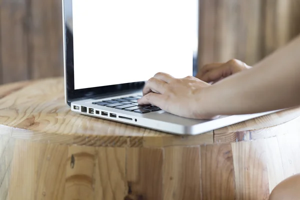Woman\'s hand on computer notebook on wooden desk