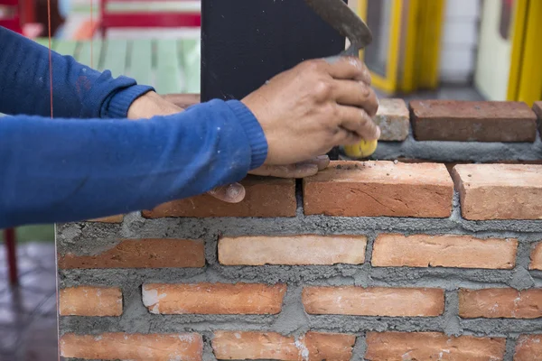 The worker is masoning the brick