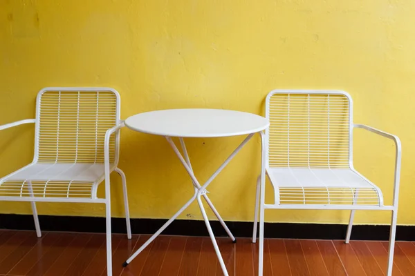 White chair and desk with yellow wall