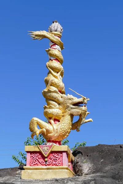 Golden dragon statue on pillar on the stone