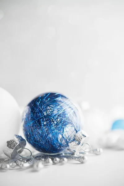 Blue and white xmas ornaments on glitter holiday background. Merry christmas card. Winter theme. Happy New Year.