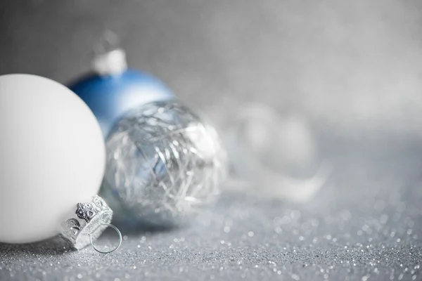 Blue, silver and white xmas ornaments on glitter holiday background. Merry christmas card. Winter holidays. Xmas theme. Happy New Year.