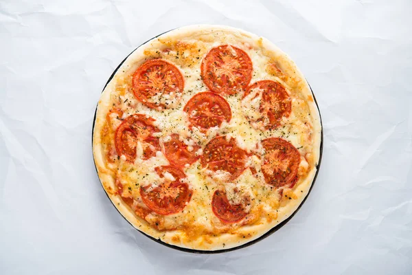 Pizza with tomato, cheese and dry basil on white background top view. Italian cuisine.