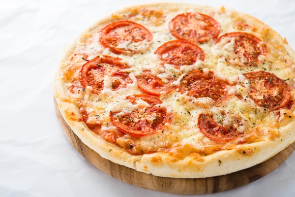 Pizza with tomato, cheese and dry basil on white background close up. Italian cuisine.