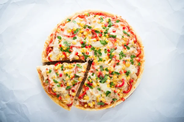 Sliced pizza with mozzarella cheese, chicken, sweet corn, sweet pepper and parsley on white background top view. Italian cuisine.