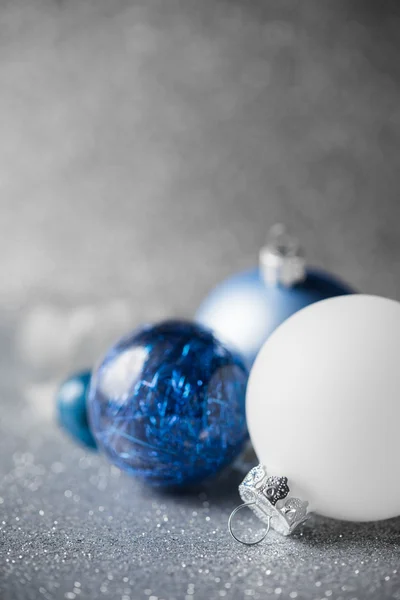 Blue, silver and white xmas ornaments on glitter holiday background. Merry christmas card.