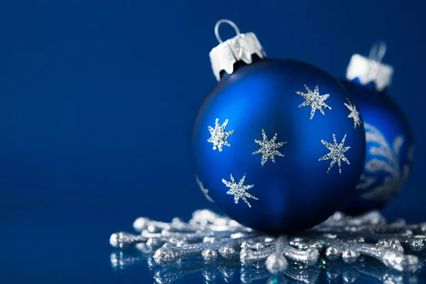 Blue and silver christmas ornaments on dark blue background with space for text. Xmas theme.