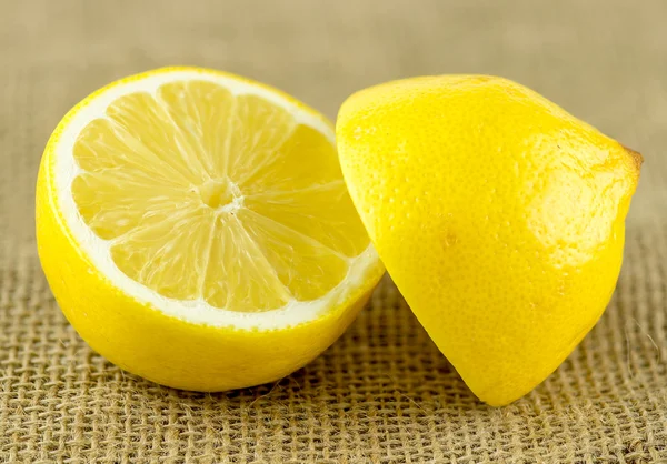 Unpeeled lemon cut in half with bright yellow rind