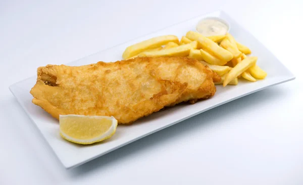 Battered fish and chips with lemon wedge and tartar sauce