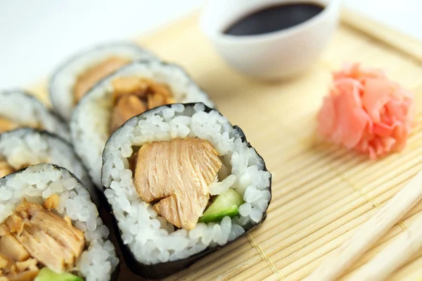 Closeup of teriyaki chicken sushi rolls with cucumber, chopstick