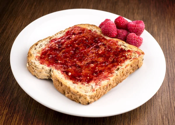 Tasty rasberry jam spread on whole wheat toast