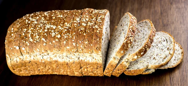 Loaf of multi-grain bread against wood