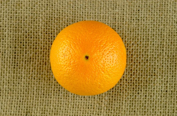 Aerial macro of bright organic orange on burlap background