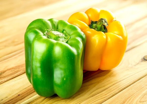 Spicy green and yellow peppers on wood
