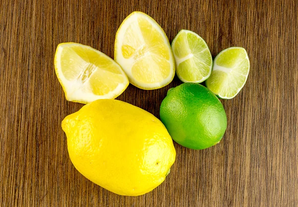 Overhead shot of vibrant ripe green limes and yellow lemons, cut