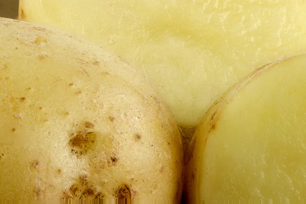 Extreme closeup of potatoes showing flesh and potato skin