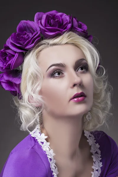 Beauty Concept and Ideas. Caucasian Female Posing in Purple Dress with Flowery Violet Crown