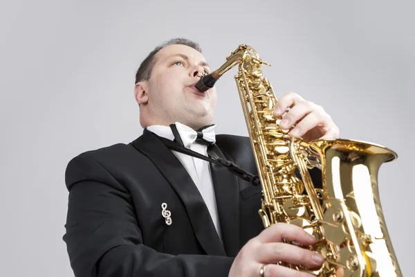 Music Themes and Ideas. One Caucasian Male Saxophonist Playing Saxophone in Studio.