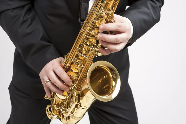 Mucs Concept. Closeup of Hands of Saxophone Player Playing on Saxophone