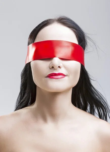 Natural Portrait of Brunette Caucasian Female with Eyes Binded with Red Lace Ribbon