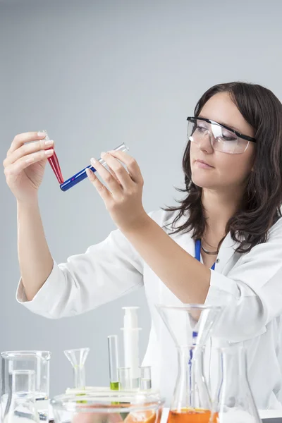 Medicine and Science Concepts. Caucasian Female Researcher Compares Substances in Two Separate Flasks