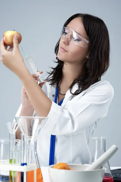 Medicine and Science Concepts. Caucasian Female Researcher Making Test Injection To the Fruits in laboratory