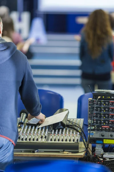 Sound Operator at Work in front of Sound Mixing Console.