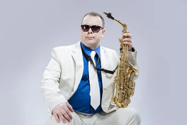 Caucasian Saxophone Player Posing with Instrument In Sunglasses Against White Background