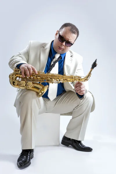 Music Ideas and Concepts. Handsome and Expressive Caucasian Musician With Alto Saxophone Posing In Sunglasses Against White Background