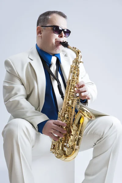 Music Ideas and Concepts. Handsome and Expressive Caucasian Music Player Posing In Sunglasses With Saxophone