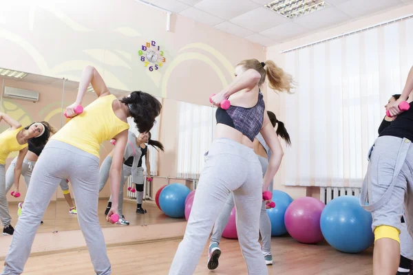 Sport and Fitness Concepts. Five Professional Sportswomen Having Trunk Bending Exercises with Barbells. In Sport Class with Fitballs Around