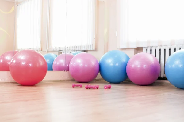 Five Fitballs and Barbells On Floor in Sport Fitness Center Indoors