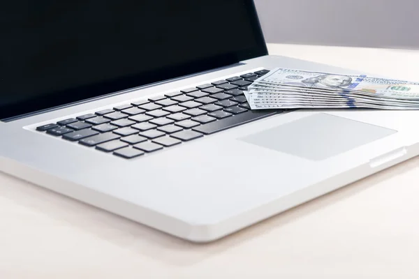 E-Trade and E-Commerce Ideas and Concepts. Stack of Banknotes on Laptop in Front of Open Screen