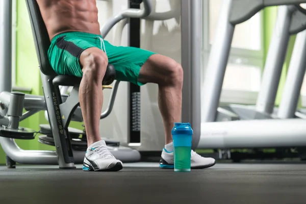 Bottle On Floor And Bodybuilder Legs