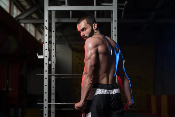 Muscular Man Flexing Muscles In Gym