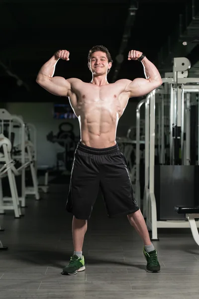 Bodybuilder Flexing Front Double Biceps Pose In Gym