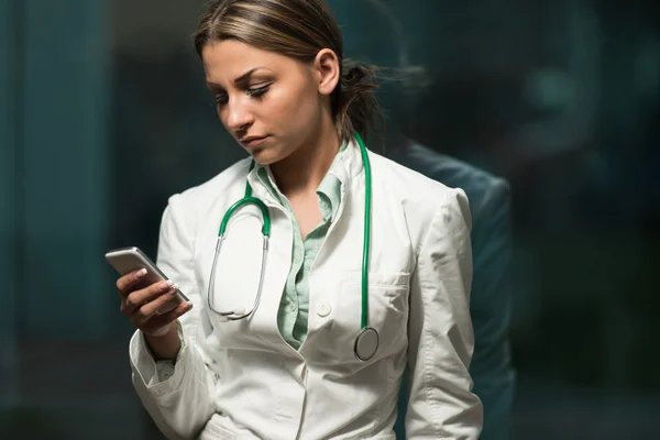 Portrait Of Female Doctor Using Her Mobile Phone